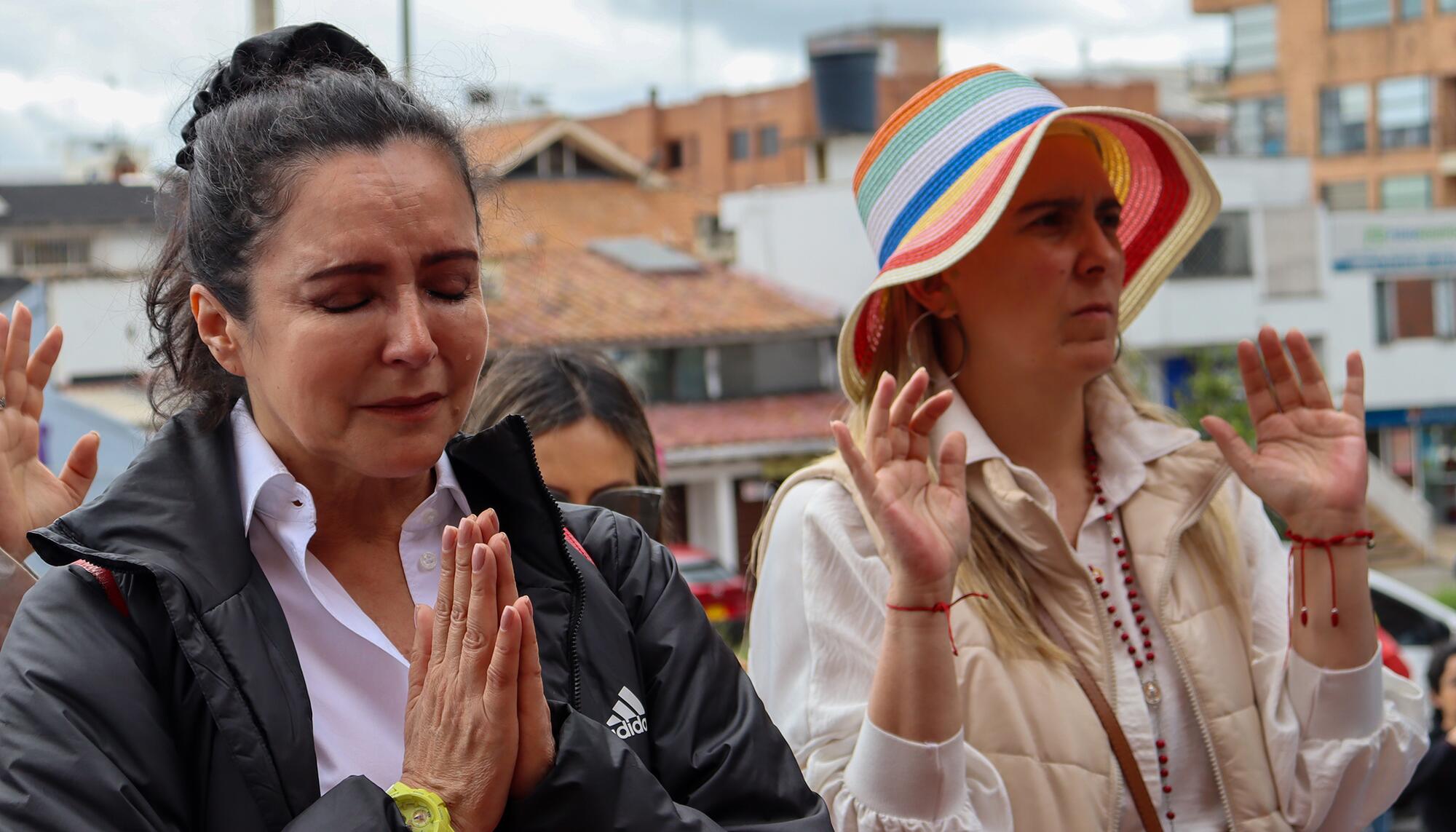 Simpatizantes de Miguel Uribe Turbay rezan fuera de la clínica.
